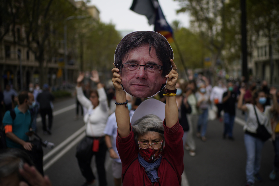 Un sostenitore di Carles Puigdemont con una maschera durante una manifestazione
