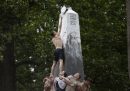 Una recluta dell'accademia della Marina militare nel Maryland posa un cappello in cima a un monumento, durante la tradizionale festa per celebrare la fine dell'anno accademico