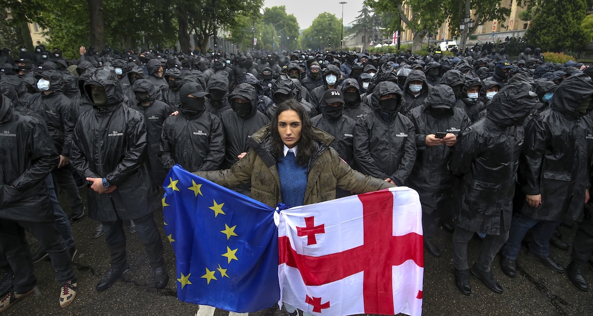 Una manifestante con le bandiere europea e georgiana a Tbilisi