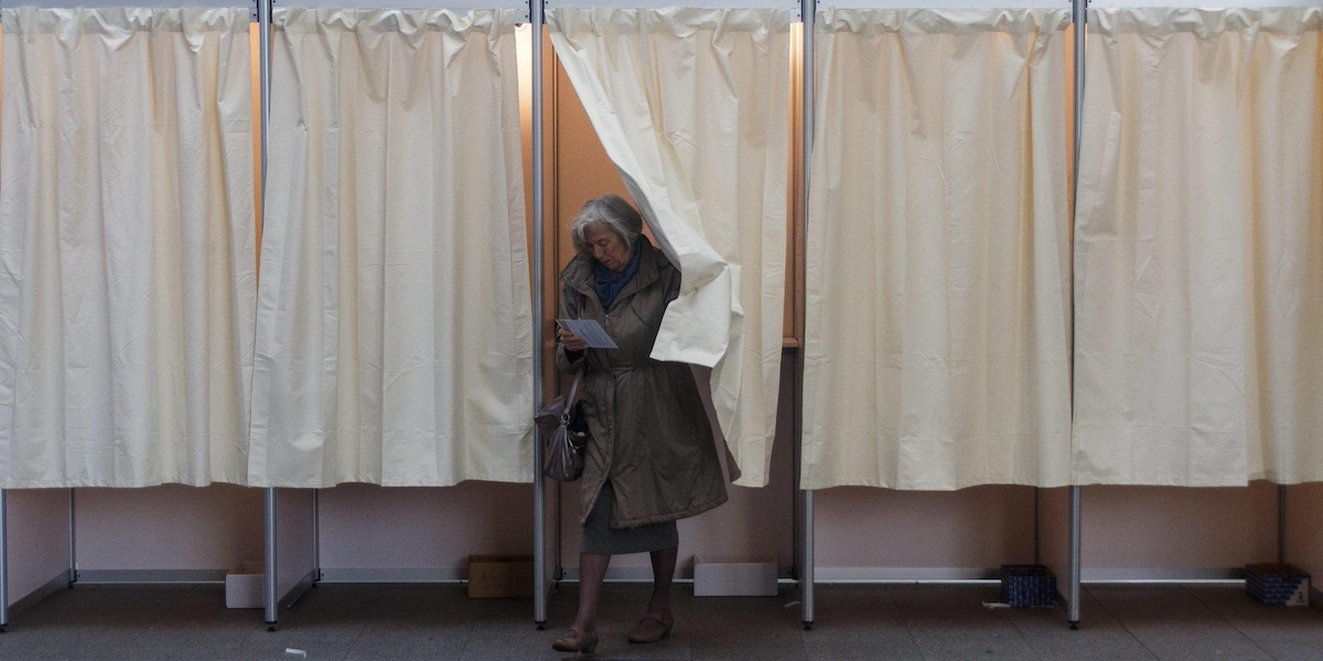 Una donna esce dalla cabina elettorale dopo aver votato alle elezioni parlamentari del 2016 a Reykjavik, in Islanda (ANSA/EPA/BIRGIR THOR HARDARSON)