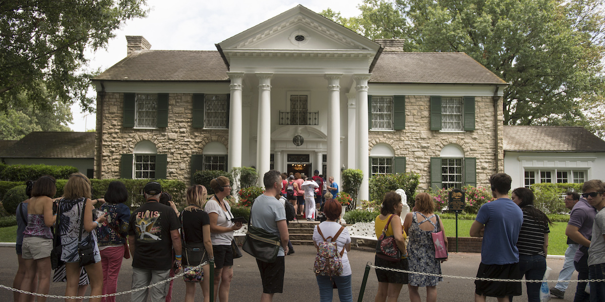 La facciata di Graceland, la grande casa appartenuta a Elvis Presley, e una fila di persone in attesa di visitarla