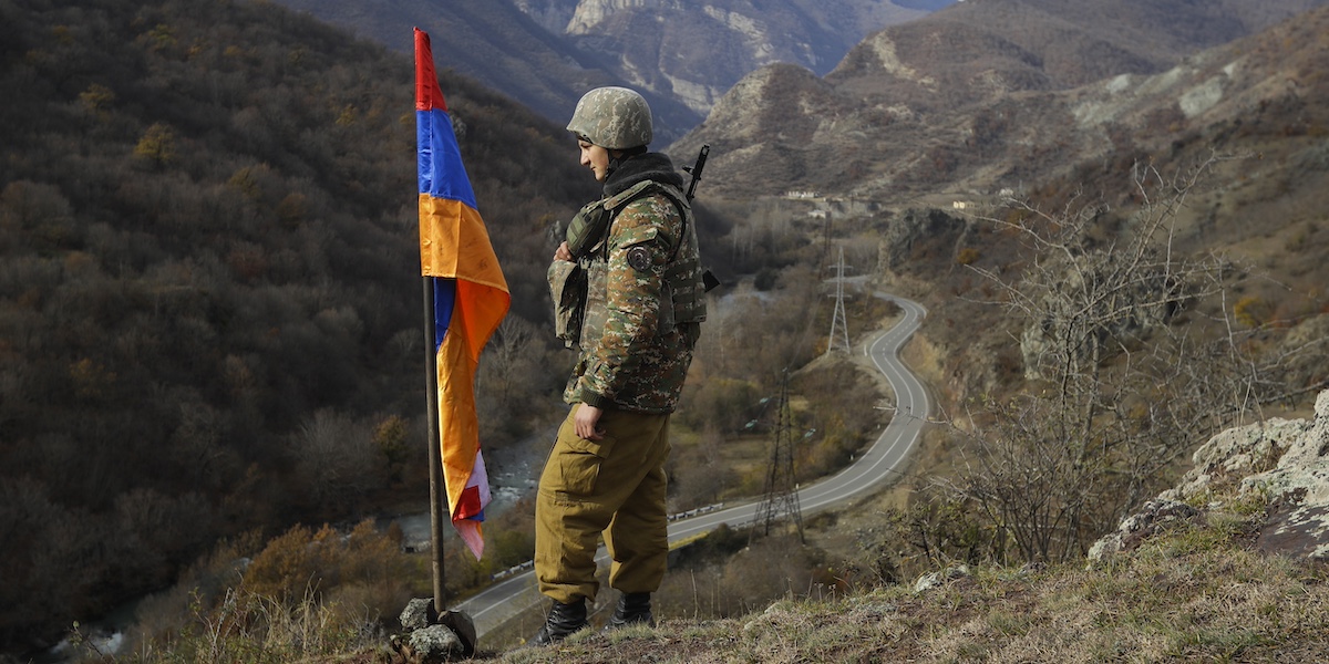 Un soldato vicino a una bandiera del Nagorno Karabakh, nel 2020 (AP Photo/Sergei Grits)