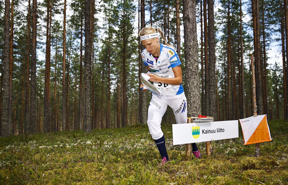 L’orientista finlandese Minna Kauppi consulta una mappa in mezzo a una radura 