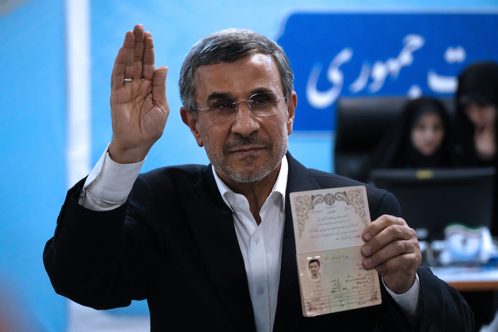 L'ex presidente iraniano Mahmoud Ahmadinejad mostra ai fotografi il suo passaporto al momento di presentare la propria candidatura 