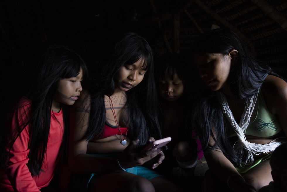 Una foto che mostra ragazze che guardano un cellulare