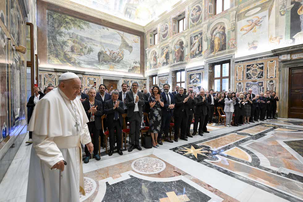 Papa Francesco entra nella Sala Clementina del Vaticano dove lo aspetta una platea di comici e comiche
