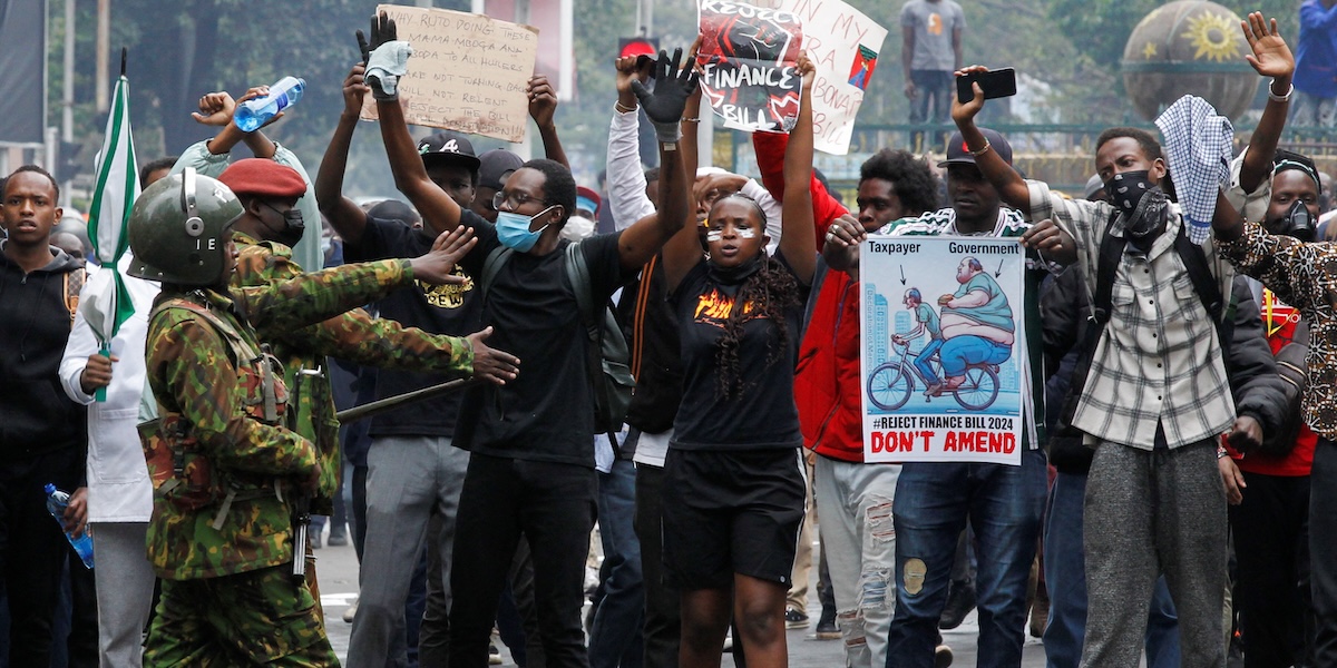 Manifestanti mostrano cartelli di protesta durante la manifestazione a Nairobi
