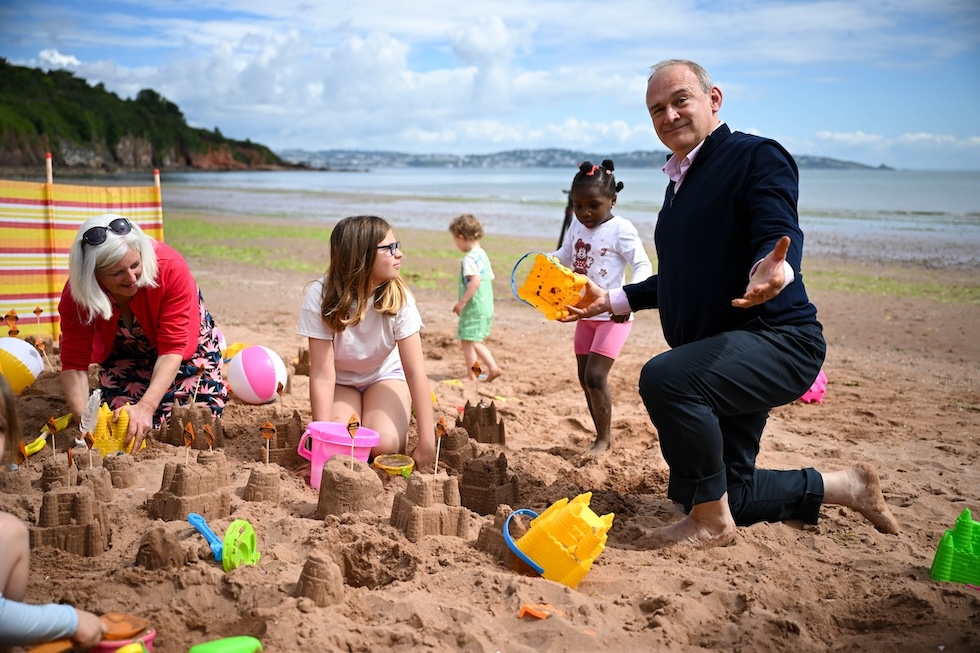 Nella foto la candidata dei Libdem Caroline Voaden ed Ed Davey fanno castelli di sabbia in spiaggia a Paignton, Inghilterra (Finnbarr Webster/Getty Images)