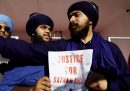 Due lavoratori indiani con un cartello per chiedere giustizia per Satnam Singh
