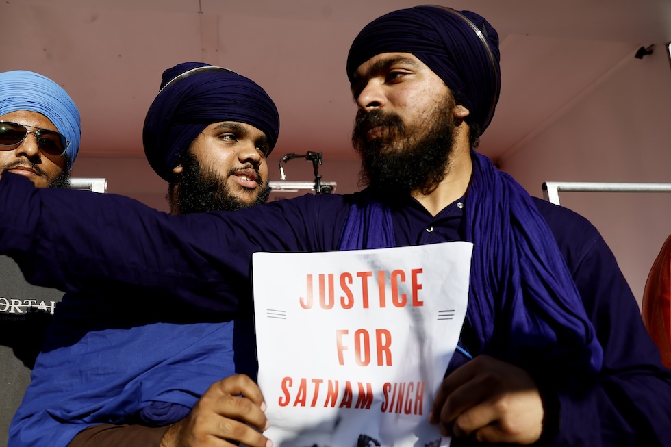 Due lavoratori indiani con un cartello per chiedere giustizia per Satnam Singh