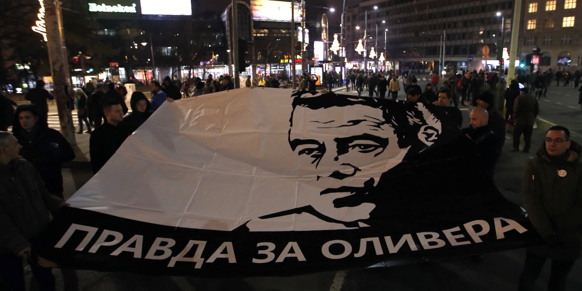 Uno striscione col volto di Ivanovic che chiede «verità per Oliver» in serbo a Belgrado, in Serbia, durante una manifestazione contro il presidente Aleksandar Vucic nel 2019 (AP Photo/Darko Vojinovic)
