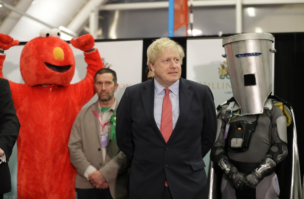 Boris Johnson mentre attende i risultati delle elezioni del 2019 nel suo collegio di Uxbridge and South Ruislip con due candidati satirici alle spalle