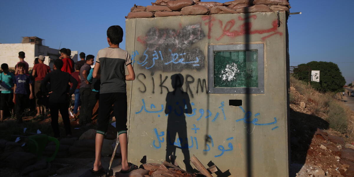 Un ragazzino osserva una manifestazione anti-turca vicino ad Aleppo, in Siria, l'1 luglio 2024 (EPA/BILAL AL HAMMOUD)