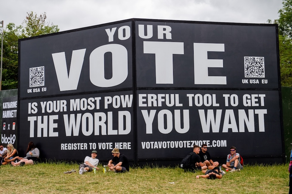 Un poster invita le persone ad andare a votare durante il festival musicale di Glastonbury, il 27 giugno