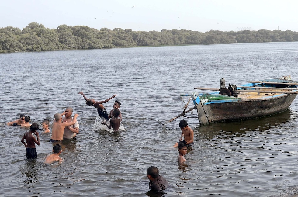 Alcune persone fanno il bagno in mare a Karachi, l'1 luglio