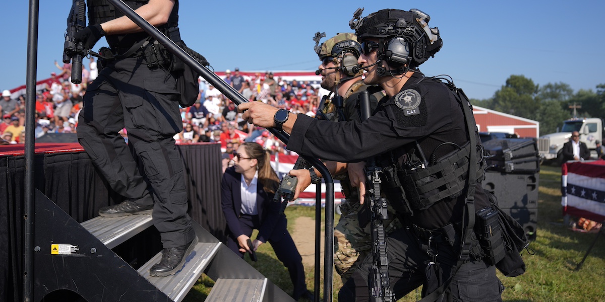 Agenti del Secret Service salgono sul palco del comizio di Donald Trump a Butler, in Pennsylvania, dopo gli spari (AP Photo/Evan Vucci)