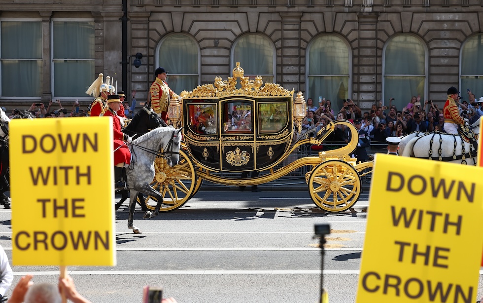 I cartelli alzati dai manifestanti repubblicani e anti-monarchici al passaggio della carrozza del re diretta in parlamento