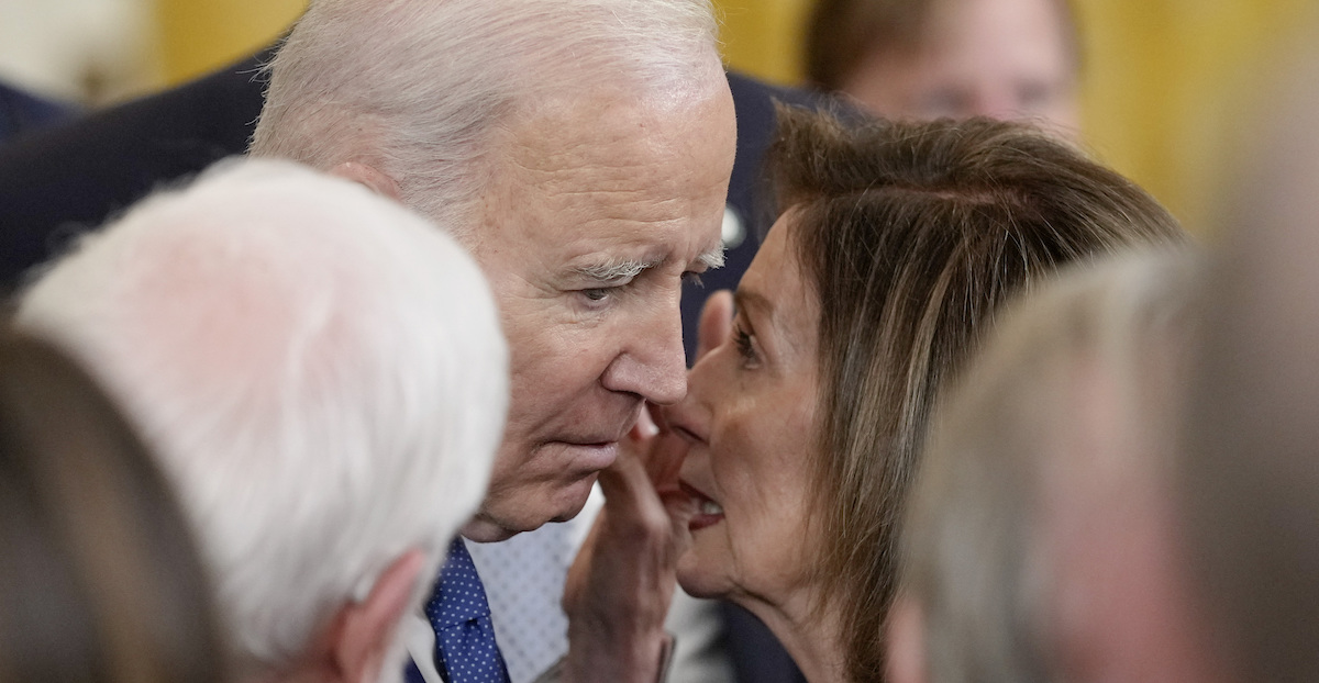 Nancy Pelosi parla all'orecchio di Joe Biden durante un evento nel 2023