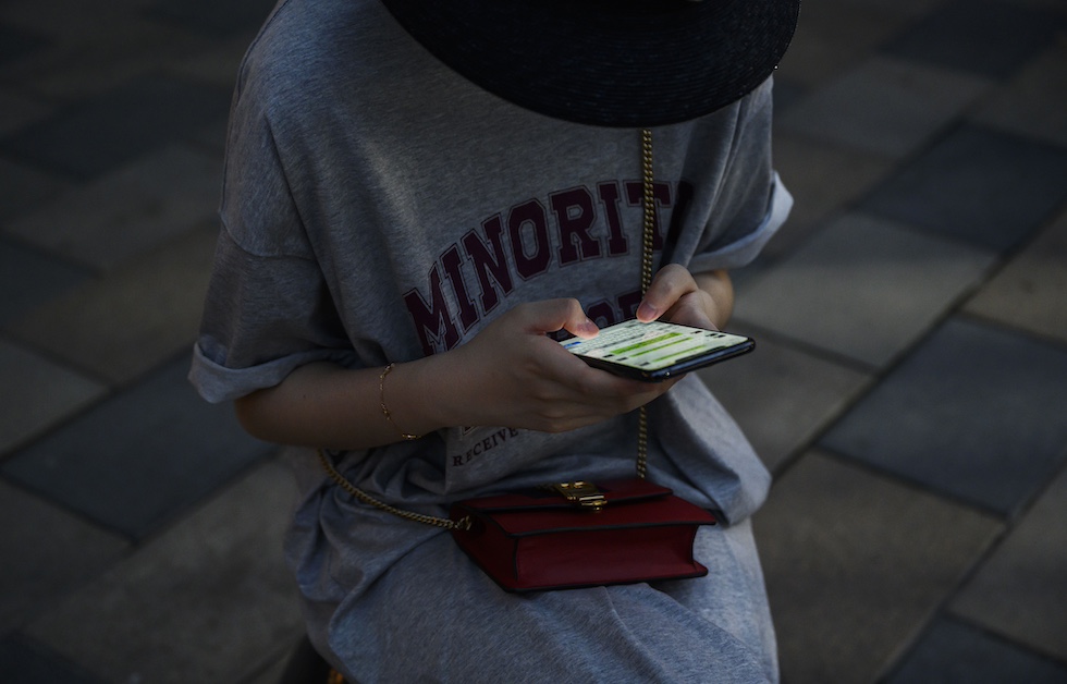 Una ragazza scrive un messaggio su uno smartphone