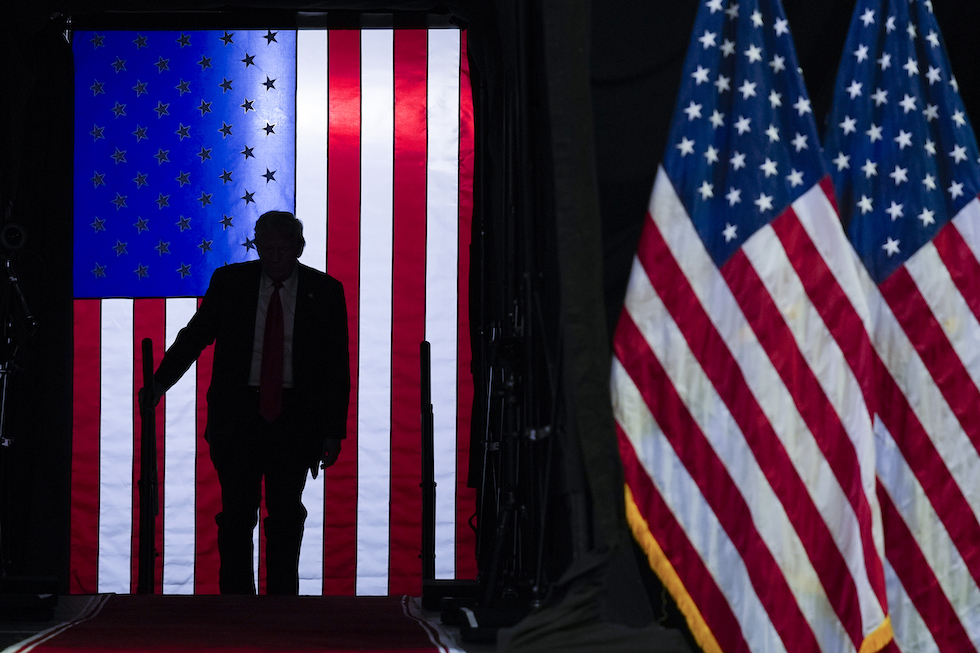 Donald Trump sale sul palco durante un evento elettorale in Michigan