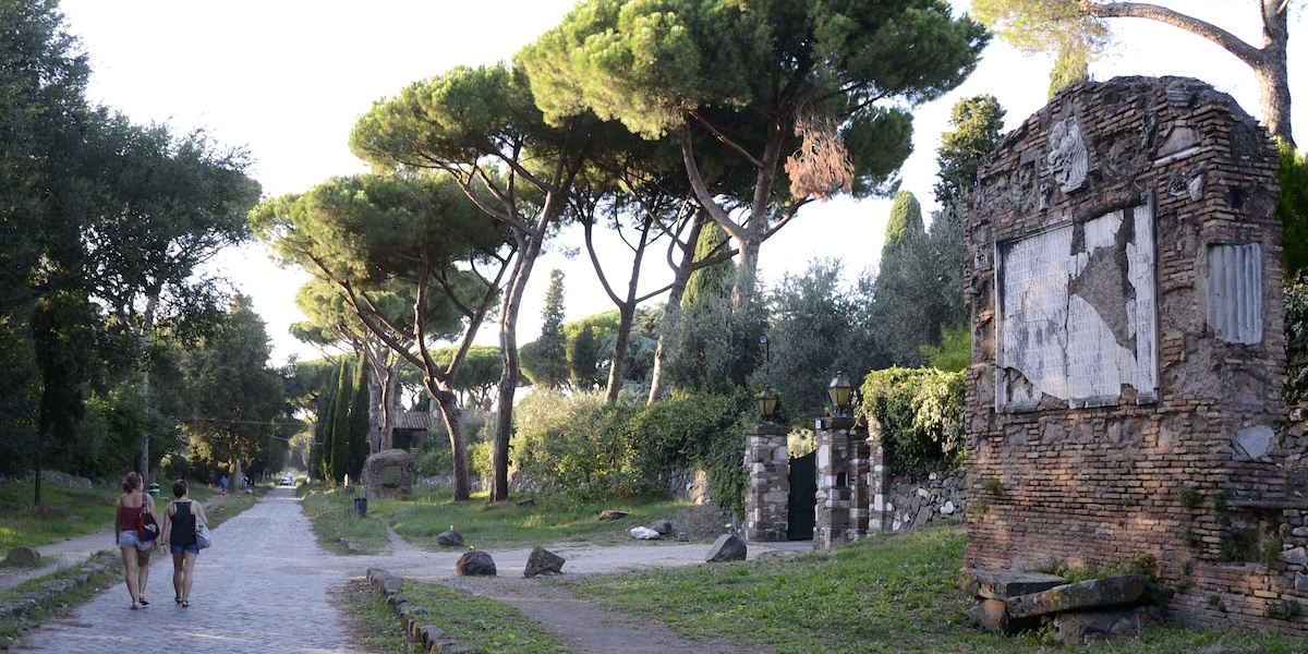 Persone che camminano lungo la via Appia Antica, a Roma