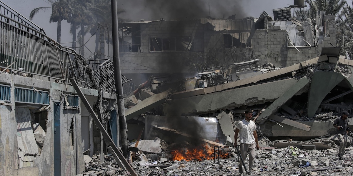 Un uomo palestinese in mezzo alle macerie della scuola bombardata da Israele