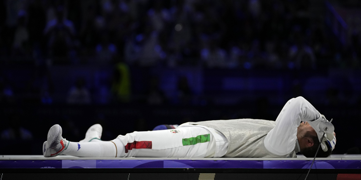 Filippo Macchi steso a terra dopo aver perso la finale di fioretto individuale maschile contro Cheung Ka Long, lunedì 29 luglio 2024 (AP Photo/Andrea Medichini)
