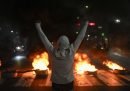 Un manifestante di fronte ad alcuni copertoni incendiati, a Caracas il 29 luglio