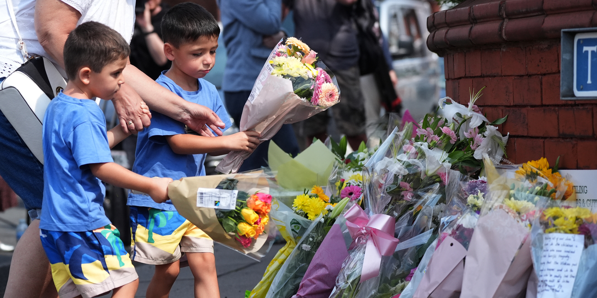 Dei bambini lasciano fiori nel punto in cui lunedì un gruppo di coetanei è stato accoltellato, a Southport (Christopher Furlong/Getty Images)