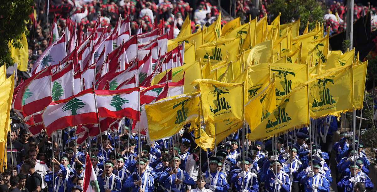 Una manifestazione di Hezbollah in Libano nel 2022, con bandiere libanesi a sinistra e di Hezbollah a destra