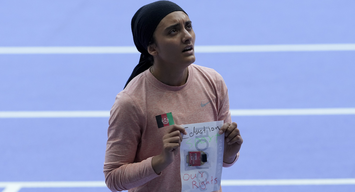 Kimia Yousofi mostra un foglio con scritto: «Istruzione, Sport, i nostri diritti»