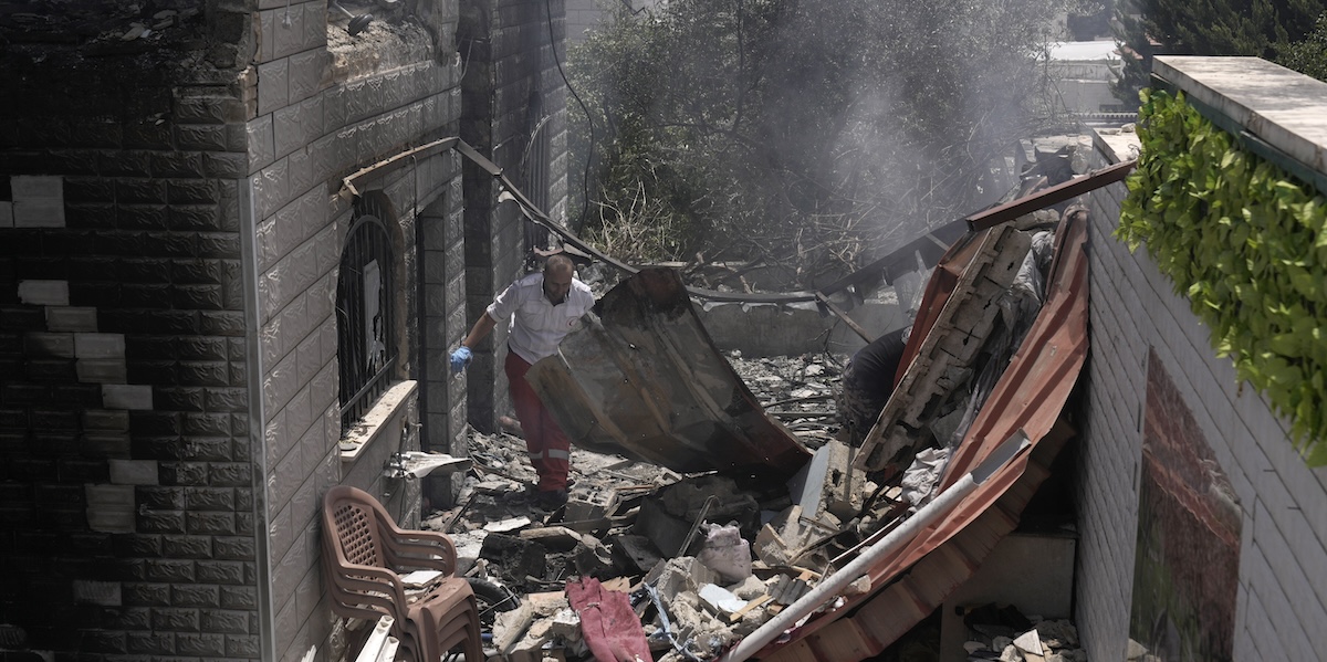 Un operatore di soccorso tra i detriti di un edificio bombardato a Jenin, lo scorso 5 lugli