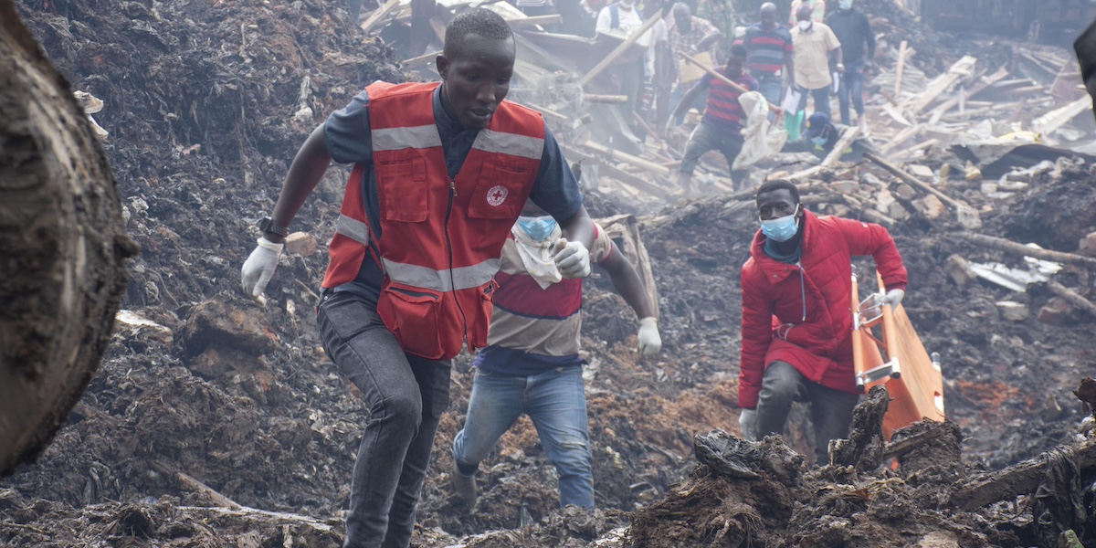 Un soccorritore della Croce Rossa tra i rifiuti della discarica di Kiteezi, 10 agosto 2024 (EPA/ISAAC KASAMANI)