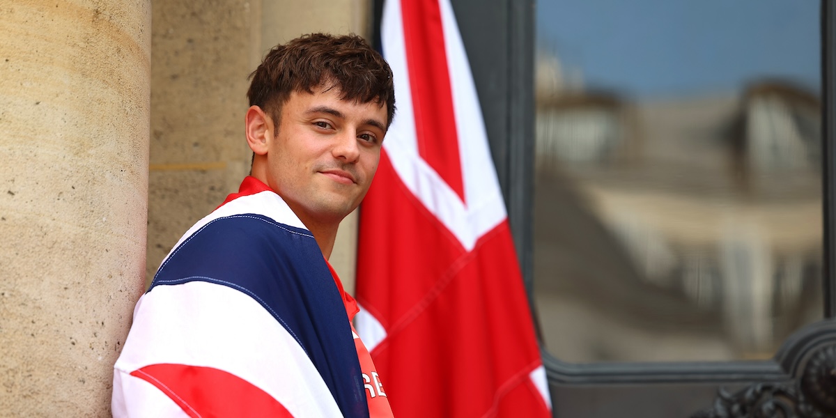 Il tuffatore inglese Tom Daley in posa per una foto con la bandiera del Regno Unito all'ambasciata del paese a Parigi, lo scorso 24 luglio (Richard Pelham/ Getty Images)