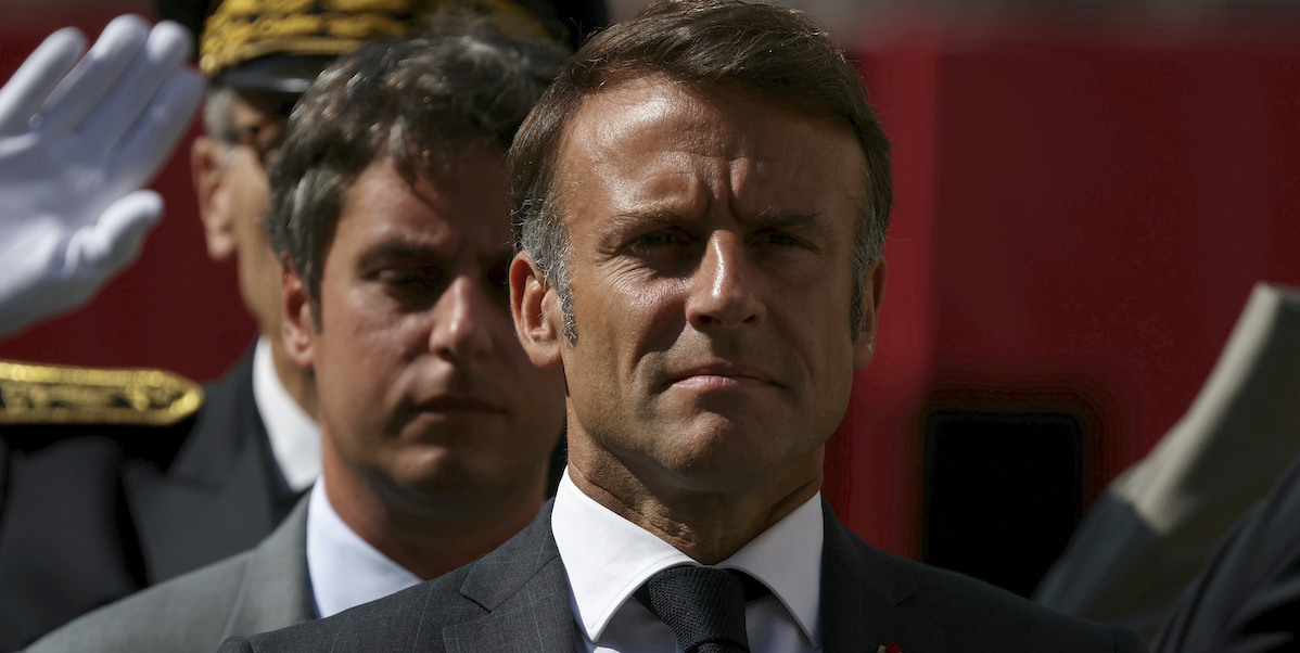 Emmanuel Macron e, dietro di lui, il primo ministro dimissionario Gabriel Attal, Parigi, 12 agosto 2024 (Alain Jocard, Pool via AP)