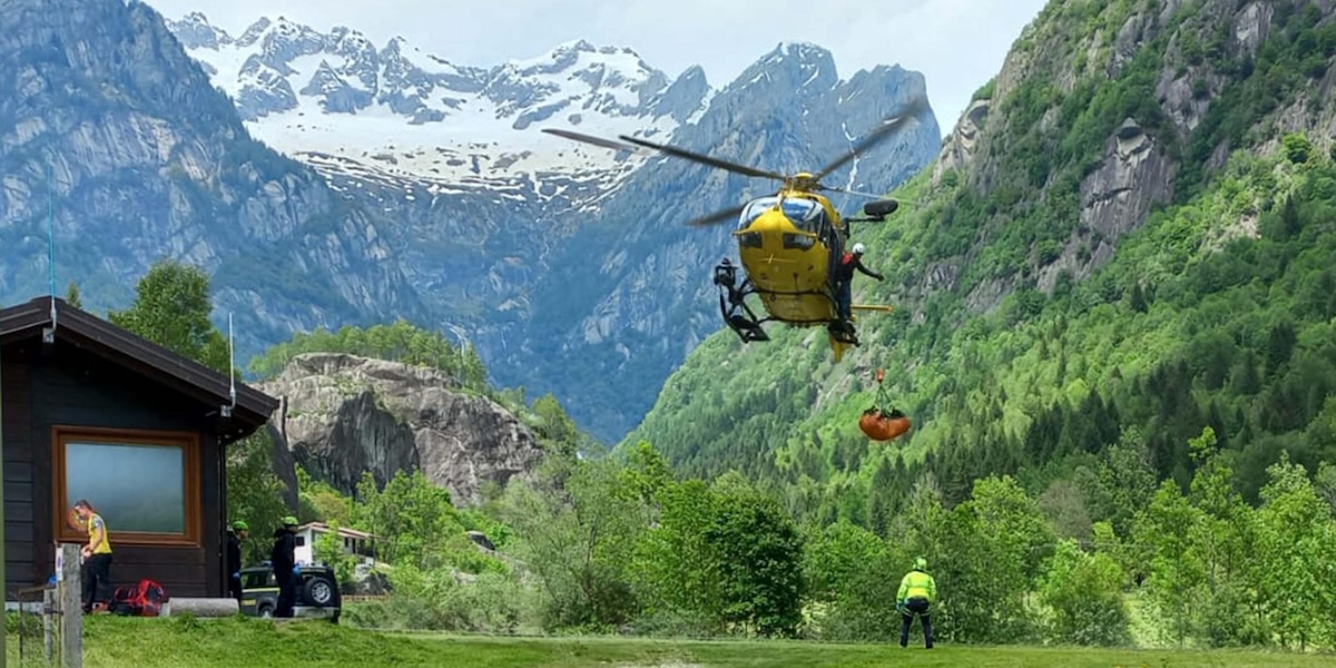 Un elicottero del soccorso alpino con alcune montagne sullo sfondo