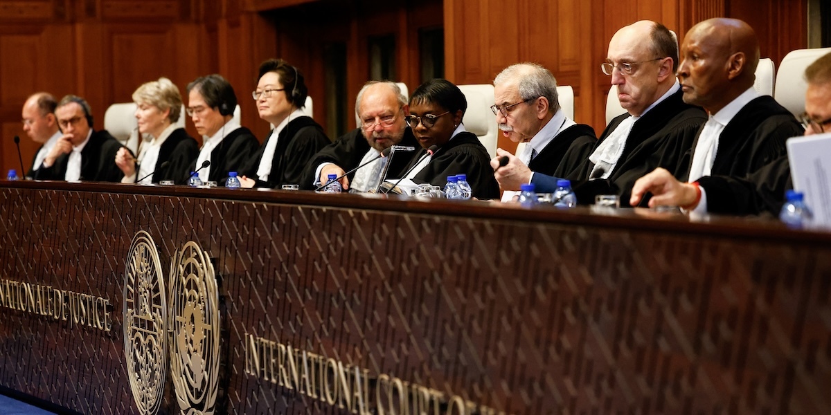 Dieci giudici dell'ICJ, sia uomini che donne, di diverse nazionalità siedono al banco della Corte vestiti con le ufficiali toghe nere