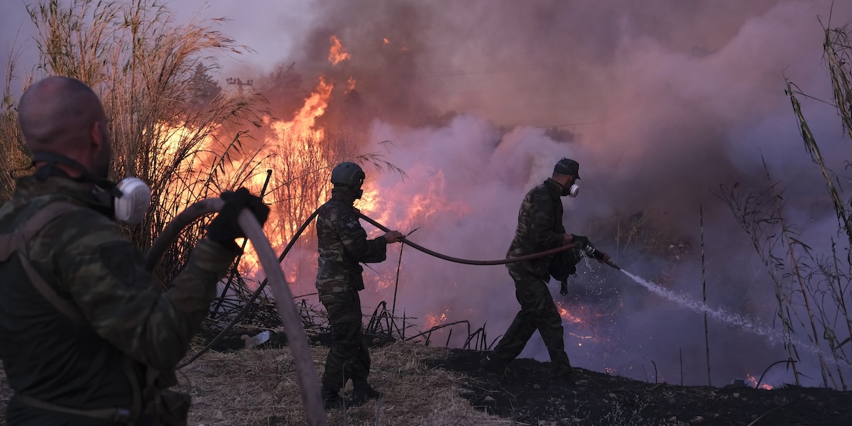 Vigili del fuoco durante le operazioni di spegnimento dell'incendio vicino ad Atene, in Grecia