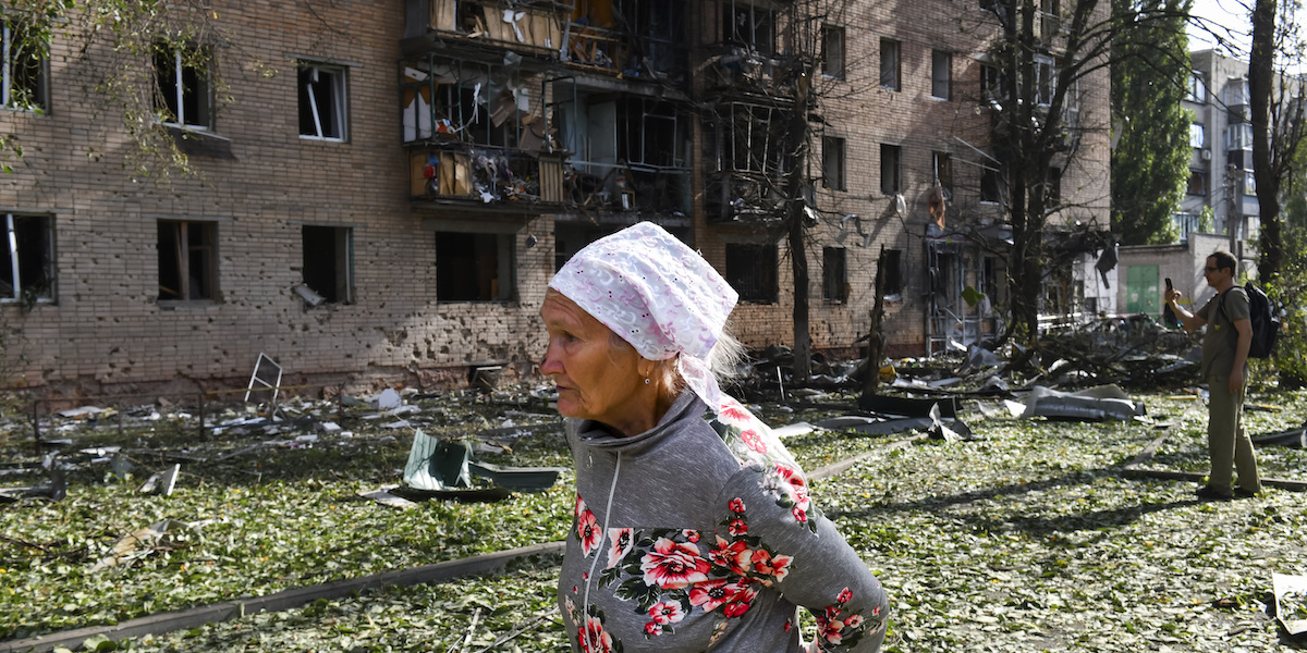 Una donna davanti a un palazzo distrutto da un bombardamento ucraino nella regione di Kursk, in Russia (AP Photo)