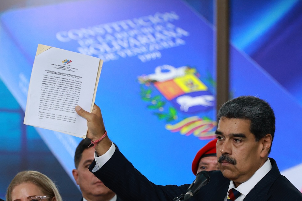 Il presidente venezuelano Nicolás Maduro mostra alcuni documenti durante una conferenza stampa alla Corte suprema, il 9 agosto