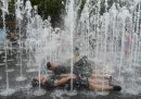 due ragazzi sdraiati sotto i getti d'acqua di una fontana