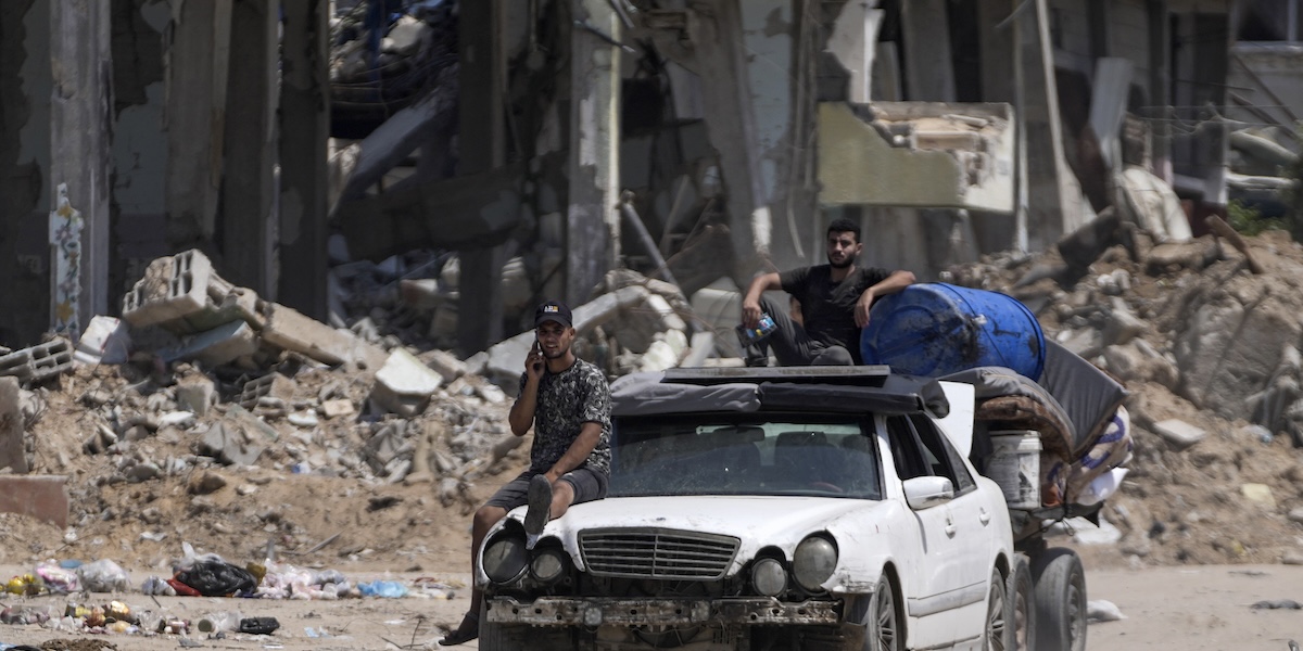 Palestinesi che abbandonano il campo profughi di Maghazi, nel centro della Striscia di Gaza, dopo un bombardamento israeliano, lo scorso 17 agosto (AP Photo/Abdel Kareem Hana)