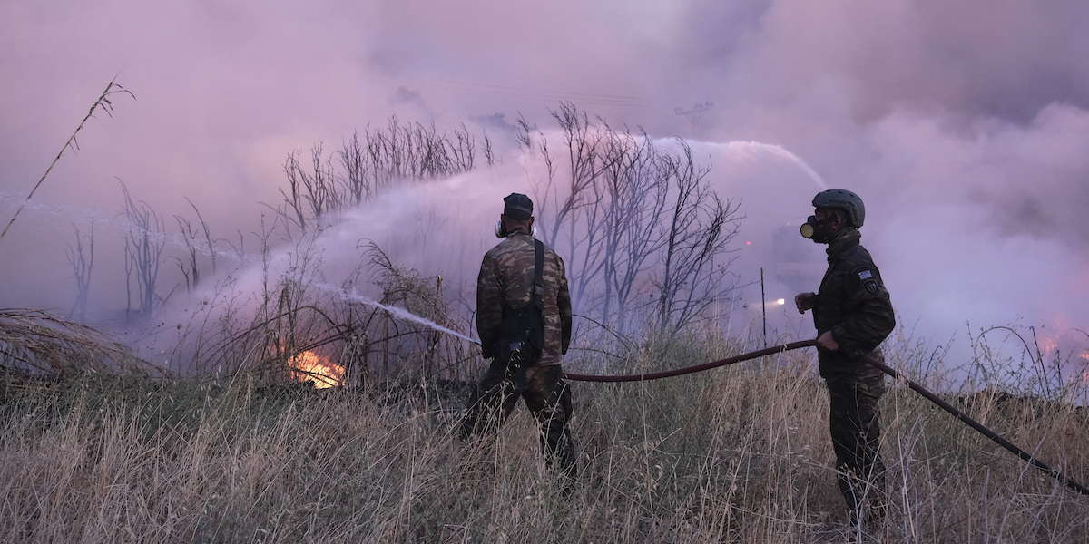 Alcuni volontari mentre cercano di spegnere gli incendi a nord di Atene, in Grecia, il 12 agosto del 2024 (AP Photo/Aggelos Barai)