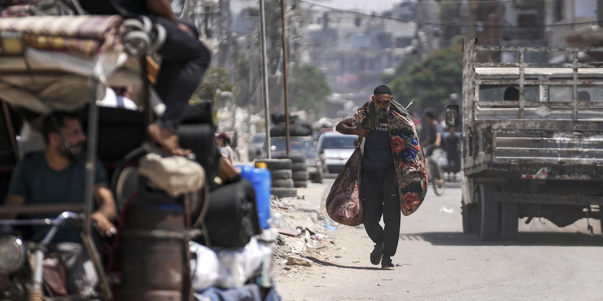 Un uomo palestinese lascia il campo di Al Maghazi, nel centro della Striscia di Gaza, dopo l'ordine di evacuazione dell'esercito israeliano, 17 agosto 2024 (AP Photo/Abdel Kareem Hana)