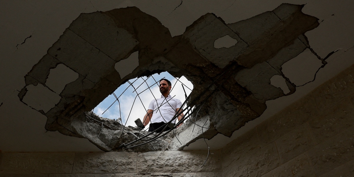 Un ispettore controlla i danni a un edificio residenziale colpito durante l’attacco di domenica di Hezbollah, nel nord di Israele (REUTERS/Ammar Awad)