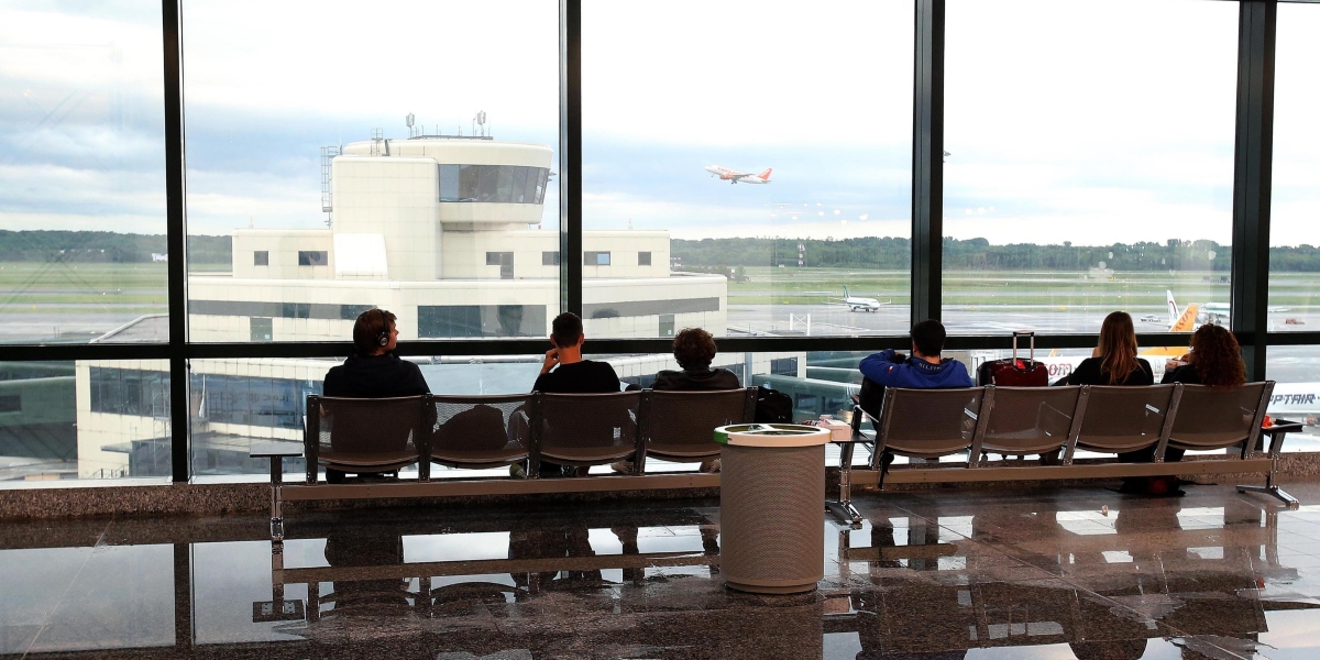 persone in attesa all'aeroporto di malpensa