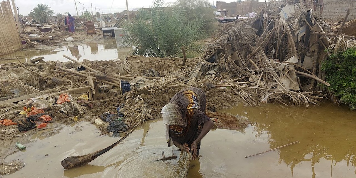 Una donna rovista tra le macerie della sua casa distrutta da un'alluvione ad Abu Hamad, nella parte centrale del Sudan, lo scorso 7 agosto (AP Photo/ Samira Hassan)