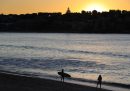 Due persone su una spiaggia, al tramonto.