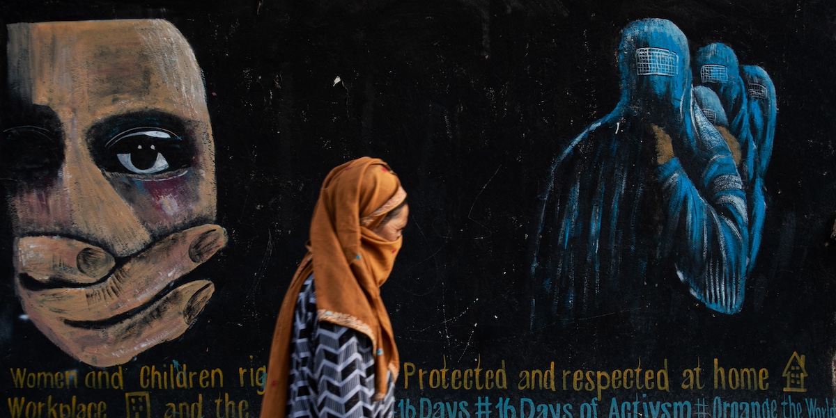 Una donna cammina di fronte a un murale nella città di Bamian, in Afghanistan, 12 agosto 2022 (Photo by Nava Jamshidi/Getty Images)