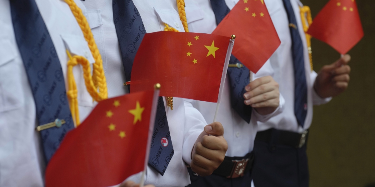 Studenti di Hong Kong con in mano delle bandiere cinesi (AP Photo/Vincent Yu, File)